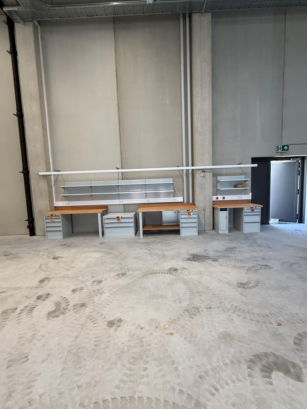 Werkbänke mit Schubladenschränken und Lochwänden in einer neuen Halle